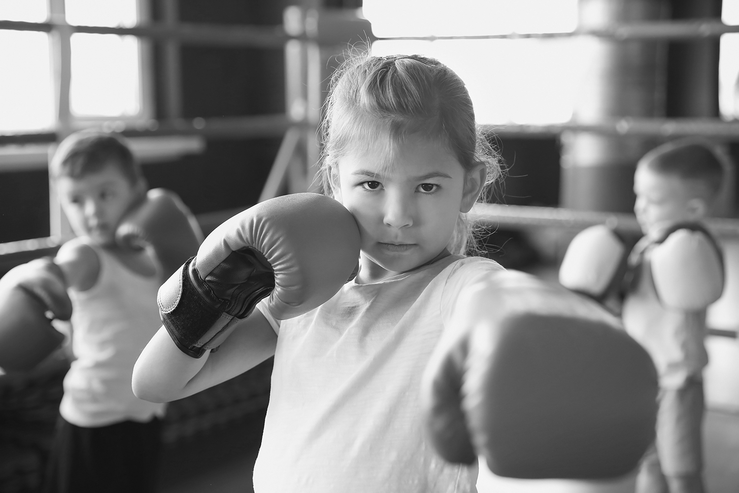 Een kind in een boksles met bokshandschoenen aan 