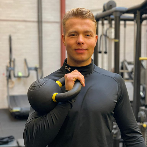 Personal trainer Medical Move Merijn Heijstek Mannelijke personal trainer in een sportschool met een kettlebell in zijn hand