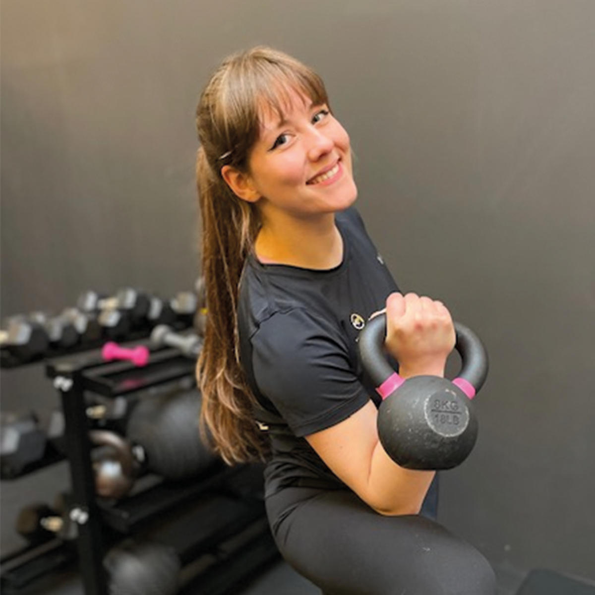 Administratief medewerkster van een sportschool met een huistelefoon in haar hand